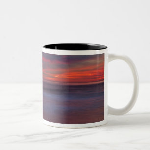 Purple-coloured sunrise on ocean shore Two-Tone coffee mug