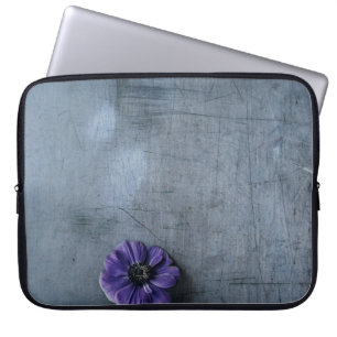 Purple petaled flower on grey surface laptop sleeve