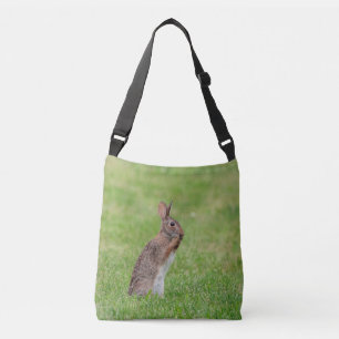 Rabbit standing in the grass and looking shy crossbody bag