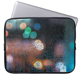 Raindrops on window, night city view through windo laptop sleeve
