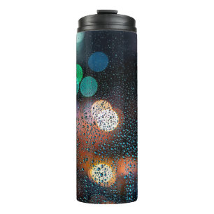 Raindrops on window, night city view through windo thermal tumbler