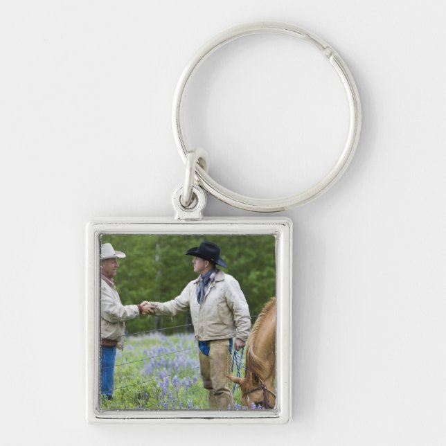 Ranchers shaking hands across the fencing in key ring (Front)