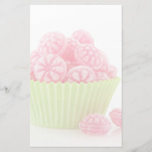 Raspberry tasty candy sweets in green cup cake stationery