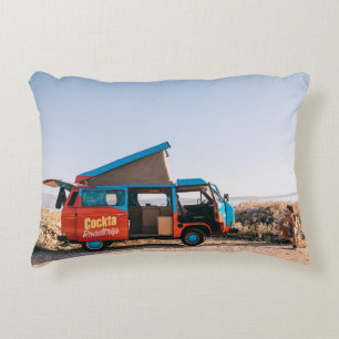Red and blue vehicle beside man decorative cushion