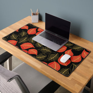 Red and gold broad leaves pattern on black desk mat