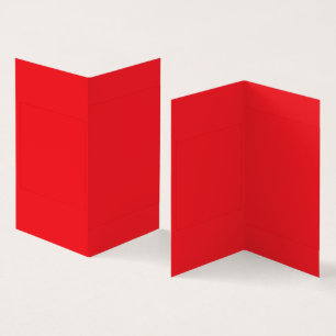 Red and orange crayons lying side by side on a whi