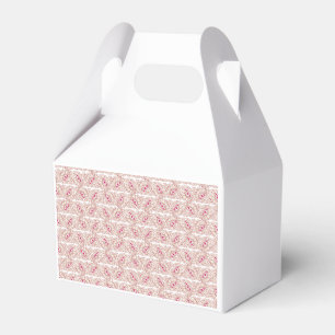 Red and pink textiles laid over a patterned rug wi favour box