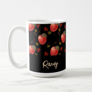 Red apples and leaves on black coffee mug
