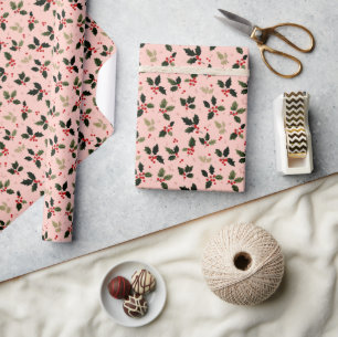 Red berries and holly on pink wrapping paper