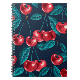 Red cherries on dark blue notebook