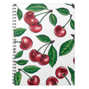 Red cherries on white notebook