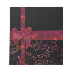 Red glitter bow and stars on black notepad