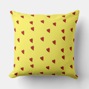 Red glossy hearts on yellow cushion