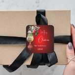 Red gold baubles Christmas Square Sticker<br><div class="desc">For a Christmas party favours or gift wrapping. A red uneven coloured background. Decorated with red and gold baubles and some greenery and a pine cone.  Personalise and add your name,  year.  Text: Merry Christmas</div>