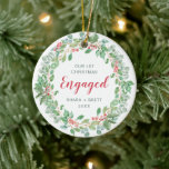 Red Green Wreath Our First Christmas Engaged Ceramic Ornament<br><div class="desc">Did you get engaged this year? Add a memory to your tree with this rustic keepsake ornament featuring a simple yet elegant design with a wreath consisting of watercolor painted greenery, red holly berries and "Our First Christmas Engaged" along with your names and year in green. This modern ornament also...</div>