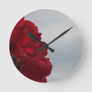 Red Roses Against a Bright Blue Sky Round Clock