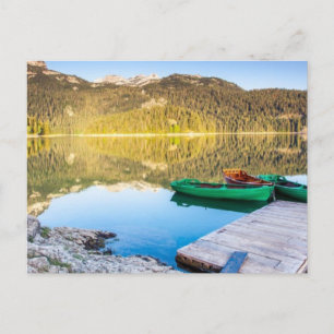 Reflection in water of mountain lakes and boats postcard
