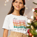 Retro believe in Santa Claus Christmas family kids T-Shirt<br><div class="desc">With its retro font style and vibrant colours,  this Christmas t-shirts bring a jolly vintage vibe to your festivities. The wording is customisable with your kid's name and reads "[name] believes in Santa Claus"</div>