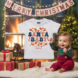 Retro Holiday Santa Baby Personalised Baby T-Shirt<br><div class="desc">Dress your little cutie in some seriously merry style with this “Santa Baby” toddler t-shirt! Featuring playful retro typography, heart-filled branches, cheerful snowmen, and your child’s name in a vintage font, this design brings the holiday spirit with a whole lot of charm. Perfect for family Christmas photos, holiday parties, or...</div>
