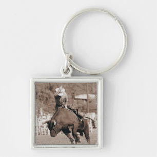 Rider about to fall off bucking bull key ring