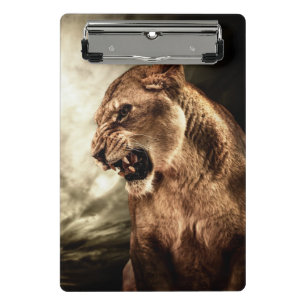 Roaring lioness against stormy sky mini clipboard