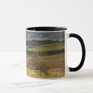 Rolling Hills And Mountains Under A Cloudy Sky Mug