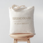 Roman Numeral Date Bridesmaid Bridal Party Tote Bag<br><div class="desc">These modern minimalist wedding tote bags make great bridal party gifts. Clean minimal design features "bridesmaid" or your choice of role,  and your wedding date in modern neutral tan serif lettering,  bisected by a single line. Your wedding date in roman numerals adds a chic touch.</div>