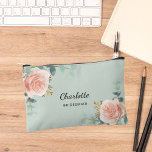 Rose gold floral sage green bridesmaid accessory pouch<br><div class="desc">A sage green background,  black and golden text. Decorated with watercolored rose gold roses,  eucalyptus greenery and golden sprigs. 
Personalise and add the name of your bridesmaid.</div>