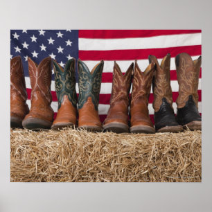 Row of cowboy boots on haystack poster