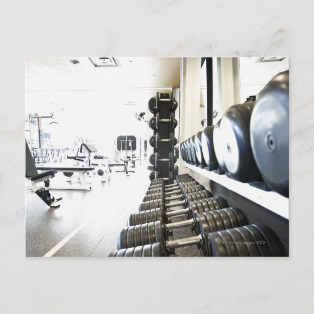 Row of free weights in foreground and exercise postcard (Front)