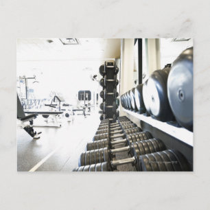 Row of free weights in foreground and exercise postcard