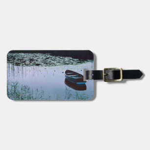 Rowboat on small lake surrounded by water luggage tag