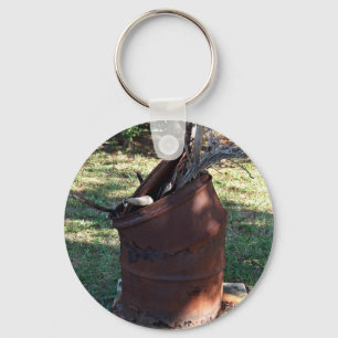 Rusted garbage can in grassy landscape key ring