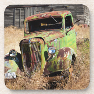 Rusting car in front of abandoned farm coaster