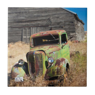 Rusting car in front of abandoned farm tile