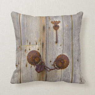 Rusty vintage old iron padlock on a wooden door . cushion