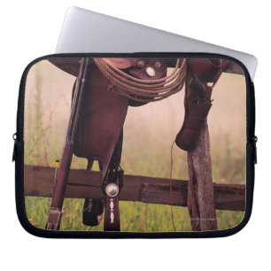 Saddle and lasso on fence laptop sleeve