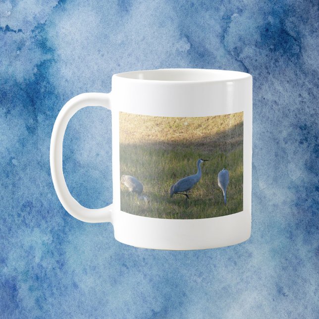 Sandhill Cranes Bird Grazing Photo Coffee Mug (A mug with a photo of three sandhill crane birds grazing in the grass.)