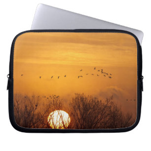 Sandhill cranes silhouetted aginst rising sun laptop sleeve