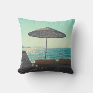 Sandy beach on a sunny afternoon, with parasols a cushion