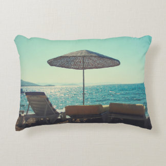 Sandy beach on a sunny afternoon,  with parasols a decorative cushion