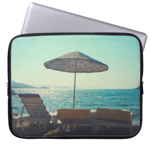 Sandy beach on a sunny afternoon, with parasols a laptop sleeve
