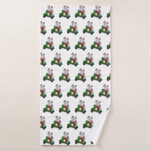 Santa and Mrs. Claus riding a scooter Bath Towel