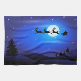 Santa and Reindeer Flying Across Blue Night Sky Tea Towel