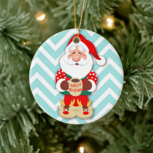 Santa claus in red pyjamas holding a mug ceramic ornament