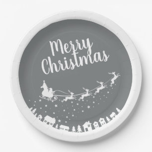 Santa's sleigh silhouette flying above the houses paper plate