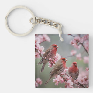 "Scarlet Trio: Red Finches Among Pink Blossoms" Key Ring
