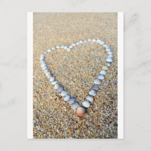 Sea shell love heart on sandy beach postcard