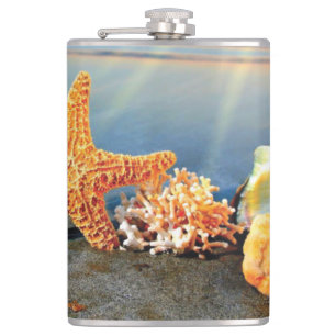 Sea shells and starfish on beach hip flask