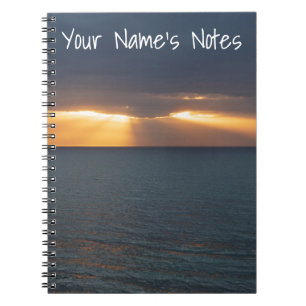 Sea sunset rays breaking through the clouds notebook